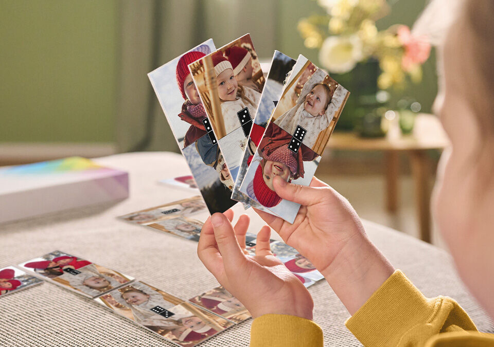 Ein Kind hält Fotos in der Hand und betrachtet sie liebevoll