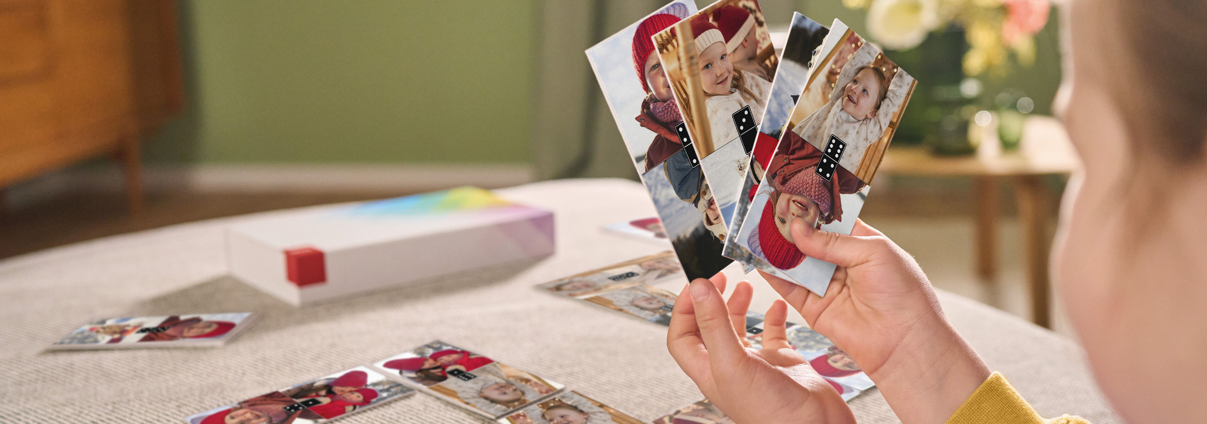 Person hält eine Auswahl von Fotokarten mit glücklichen Momenten in der Hand