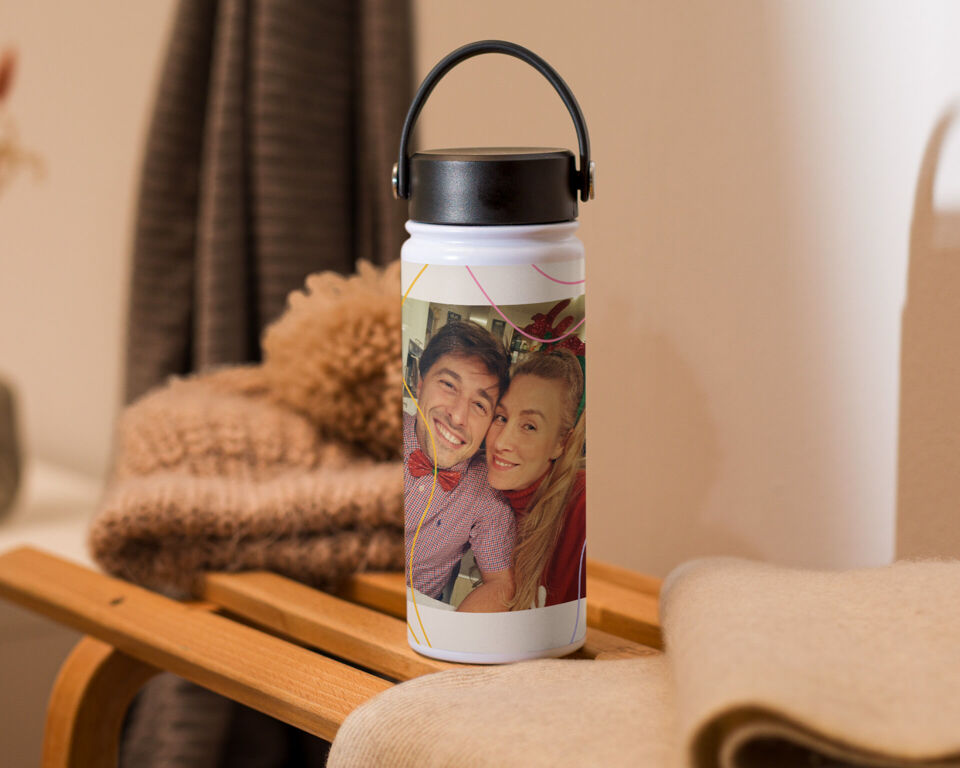 Personalisierte Trinkflasche mit dem Foto eines lächelnden Paares auf einem Holzschlitten