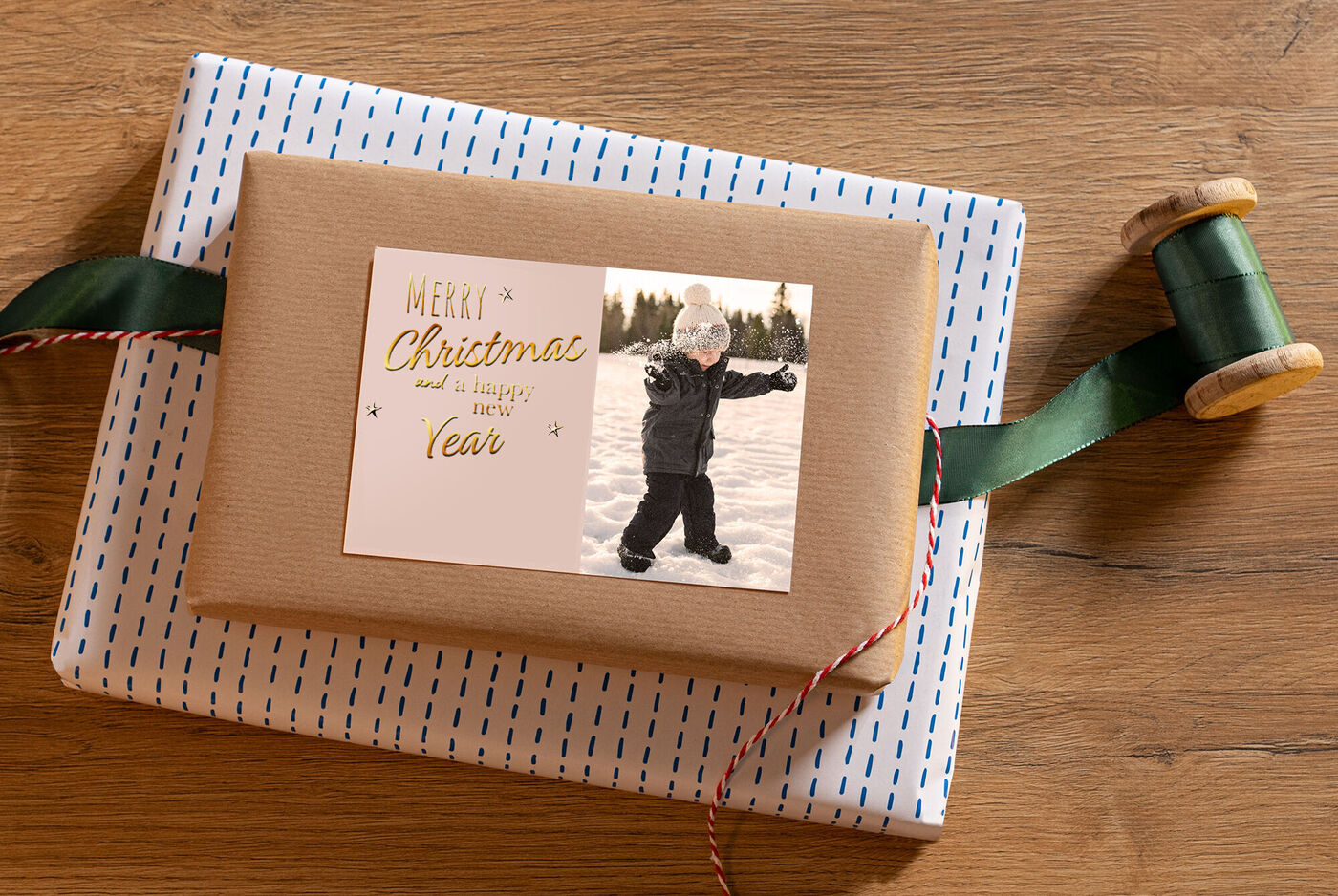 Ein liebevoll verpacktes Geschenk in festlichem Design auf einem Holztisch, umgeben von Geschenkband und einer Holzspule.