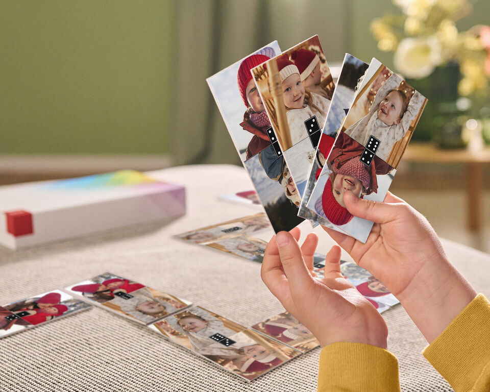 Eine Hand hält mehrere Fotos mit fröhlichen Erinnerungen
