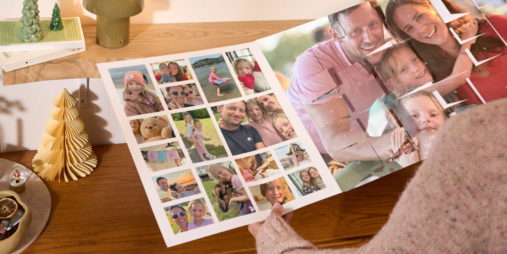XXL Foto-Adventskalender mit Poster-Collage, bedruckt mit Familienfotos, steht auf einem Holzregal neben einer Lampe und Weihnachtsdeko