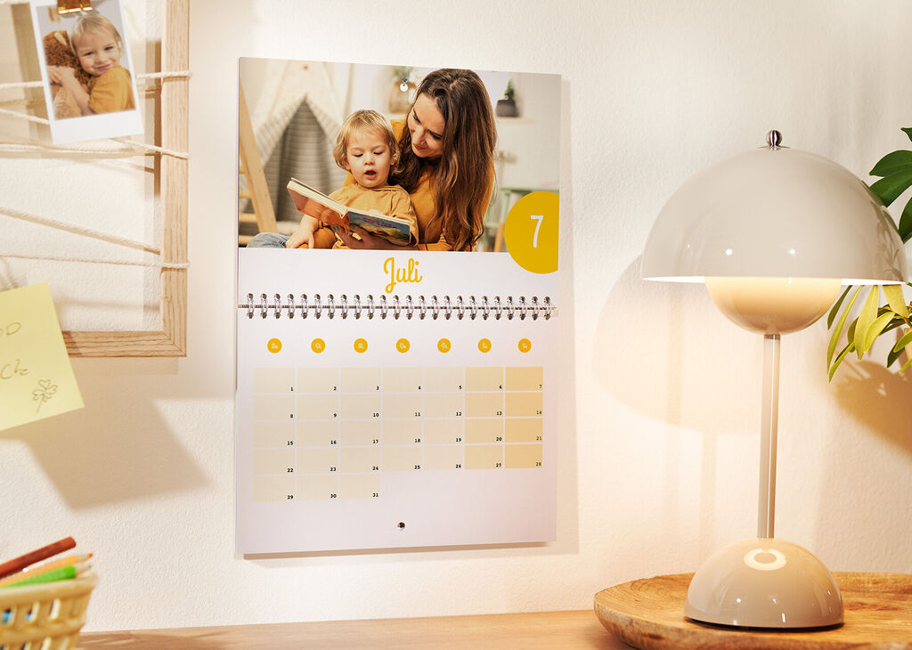 Superbe calendrier mural avec une page illustrant un instant familial pour juillet.